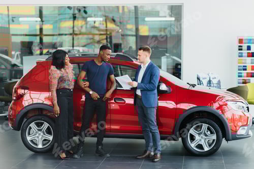 Visualização: casal africano feliz escolhendo carro de luxo em concessionária de veículos olhando para o interior