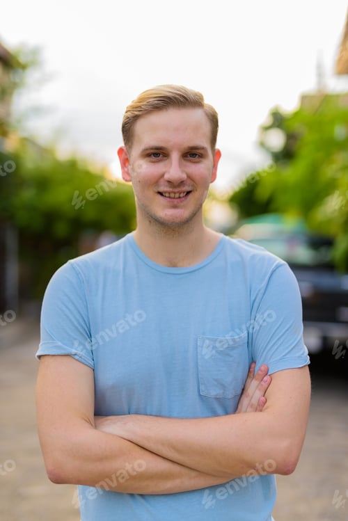 Preview: Young handsome man with blond hair in the streets outdoors