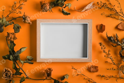Preview: Empty photo frame with dried flowers and leaves on orange background. Flat lay, top view.
