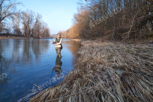 Preview: Woman catches spinning fish standing in a river