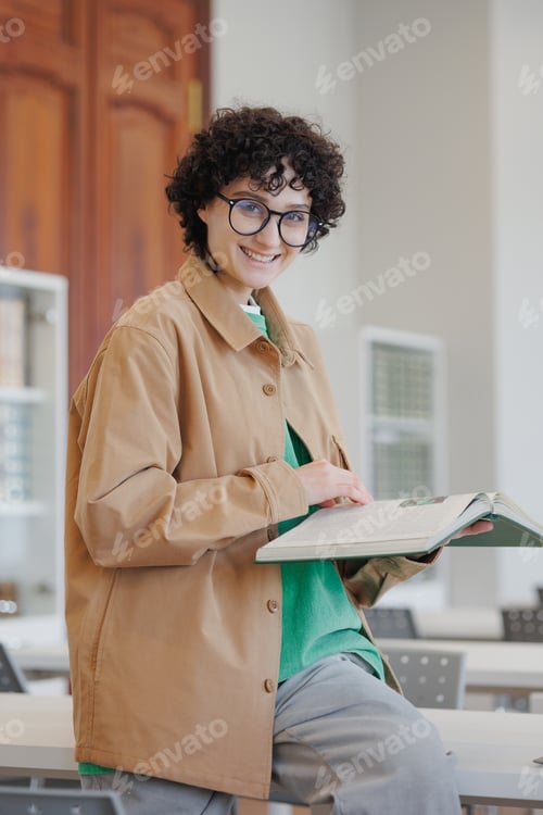 Preview: young woman in a library or coworking works on a laptop online, education and work on a creative