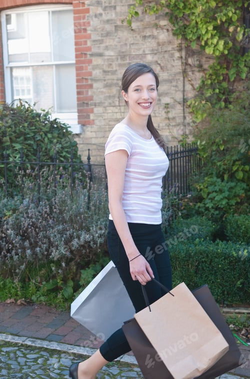Preview: Smiling woman carrying shopping bags