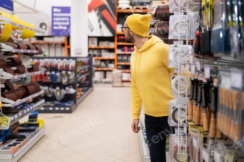 Preview: a male buyer is lost and cannot navigate in a large construction hypermarket