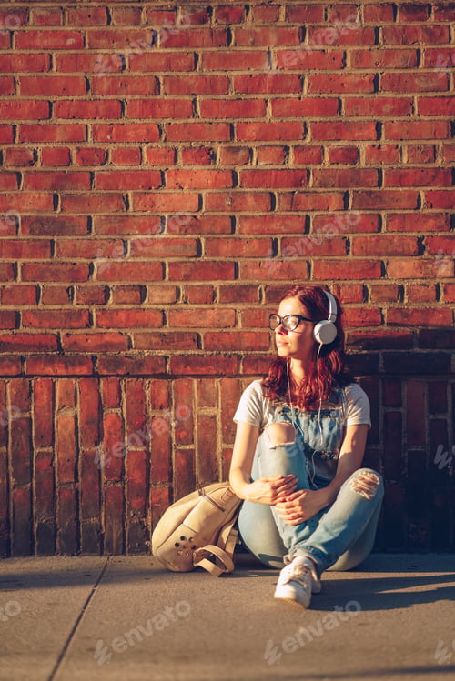 Preview: Young girl listening to music at sunset