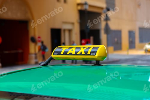 Preview: Taxi sign on the roof of a car in a street