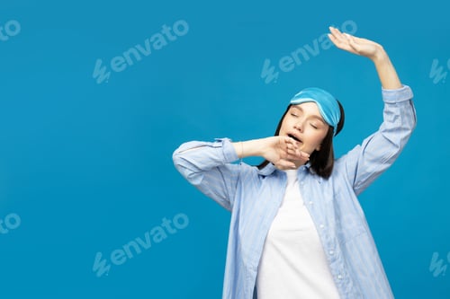 Preview: Young woman in a sleeping mask on a blue background