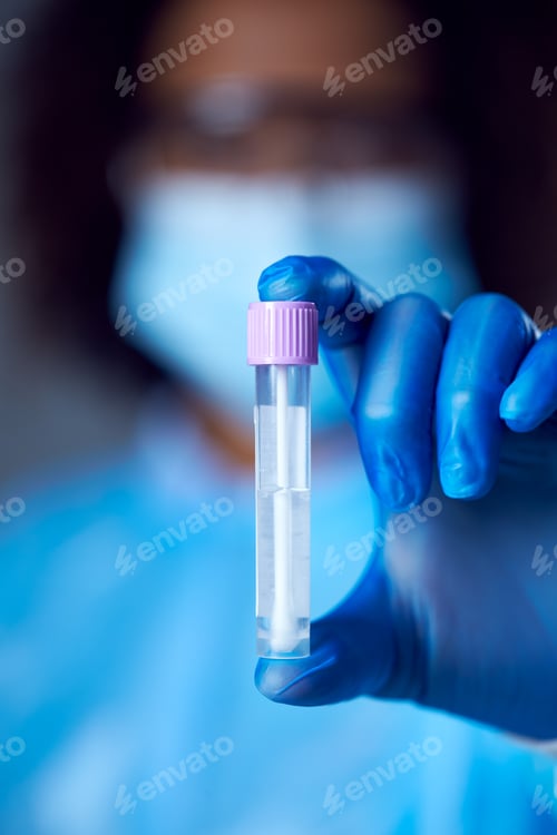 Preview: Female Lab Worker In PPE With Safety Glasses And Face Mask Holding Lateral Flow DNA PCR Test