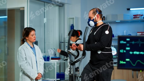 Sportsman running on cross trainer in lab facility for sports performance