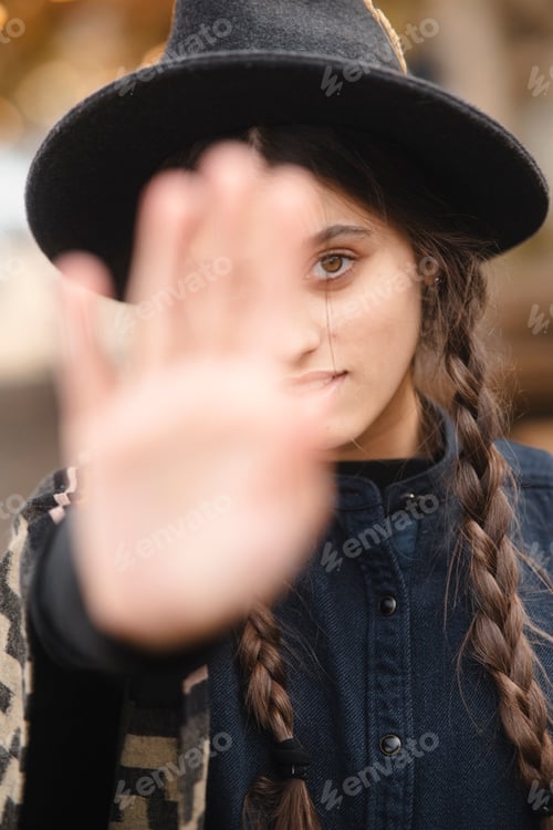 Preview: A stylish lady, embodying boho charm, dons a black hat while navigating the autumnal cityscape.
