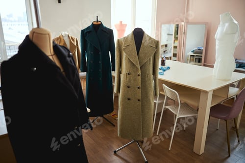 Preview: Dress stands with coats in an empty room