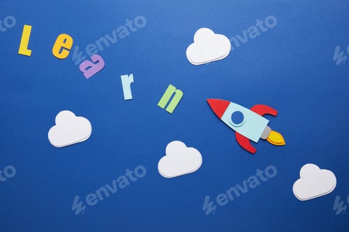Preview: top view of learn lettering with clouds and rocket on blue background