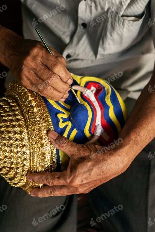 Preview: close up of artist painting lakhon khol traditional mask in cambodia