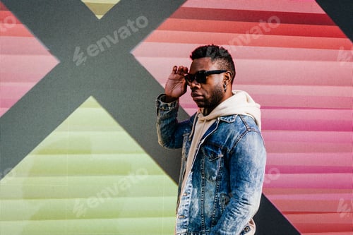 Preview: Black man posing glasses against a colorful background