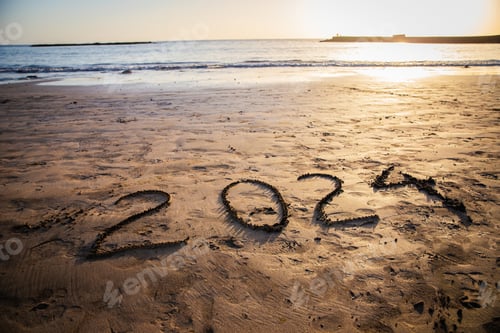 Visualização: 2024 escrito na praia durante o pôr do sol, foto de ano novo. Foto com espaço de cópia