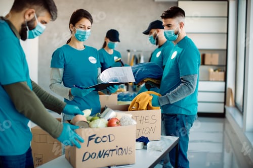 Preview: Volunteers packing charity boxes with food and clothes.