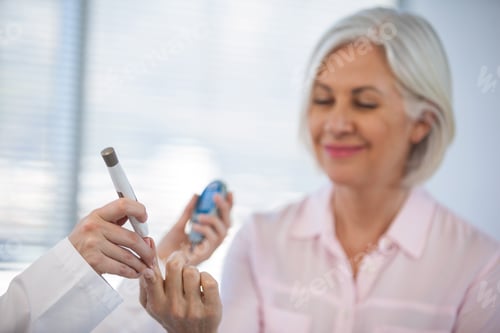 Preview: Doctor checking glucose level in diabetic patient