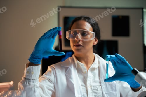 Preview: Female researcher analyzing blood sample and chemical in laboratory