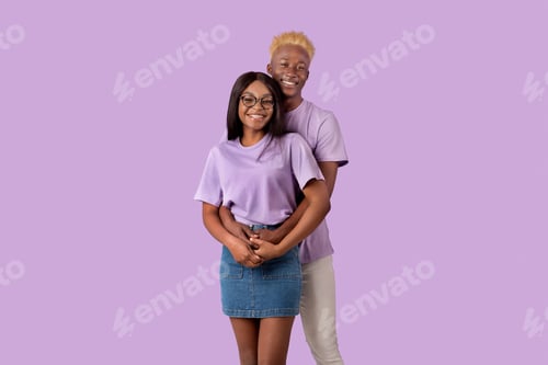 Preview: Cool millennial black couple hugging over violet studio background