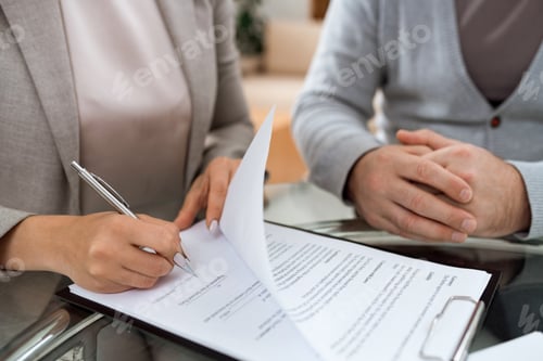 Preview: One of business partners putting signature on last page of financial contract