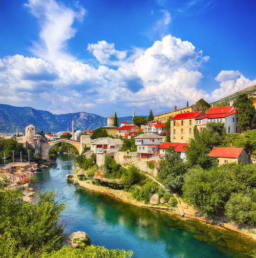 Preview: Fantastic Skyline of Mostar with the Mostar Bridge, houses and minarets, during sunny day.