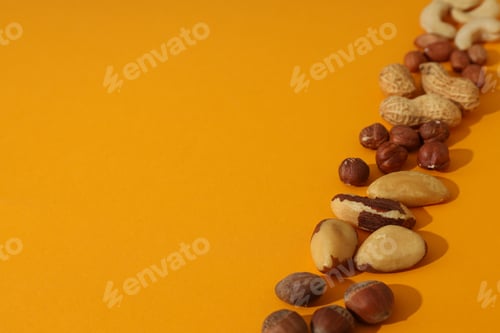 Preview: Assortment of different nuts on an orange background