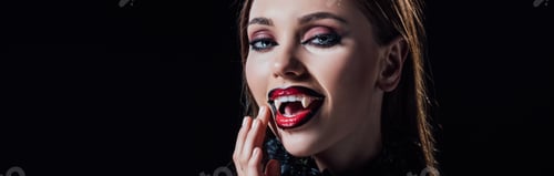 Preview: panoramic shot of scary vampire girl showing fangs in black gothic dress isolated on black