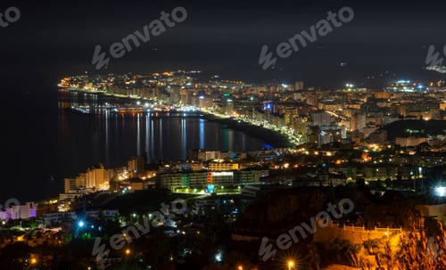 Preview: High vantage point overlooking the beautiful night-time town of Benalmadena with sea views. Spain.