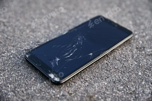 Preview: Damaged smartphone with broken touch screen on asphalt