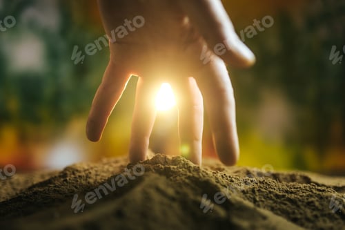 Preview: Hands pressing into soil at sunset creating a tranquil connection with nature
