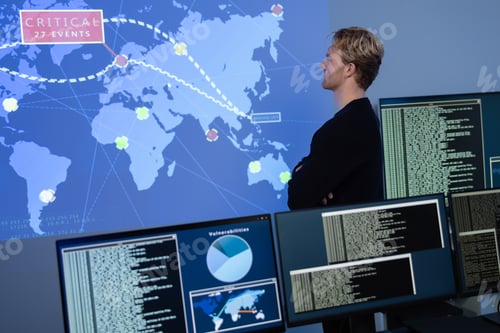 Preview: Back View in the Cyber Security Control Center Operator Working. Multiple Screens Showing Technical