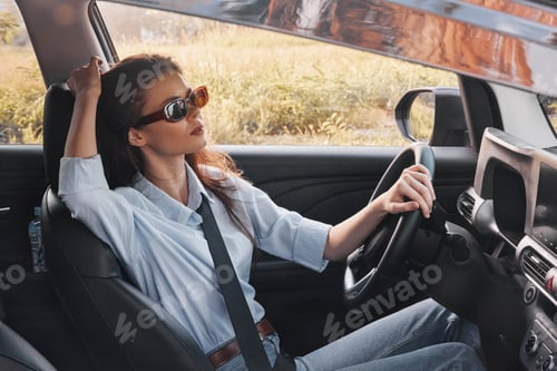 Preview: Woman, sunglasses, car, driver a woman wearing sunglasses sits in the driver seat of a car, her head