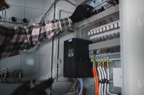 Preview: Electrician repairing electrical panel in building under construction