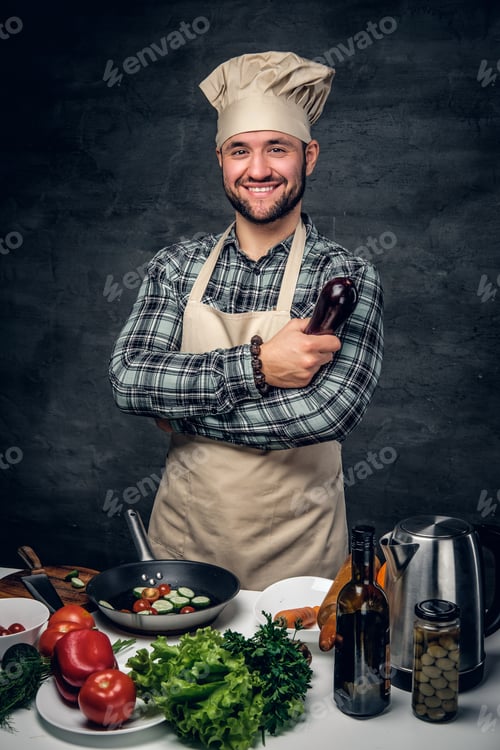 Preview: Smiling cook male holds eggplant.