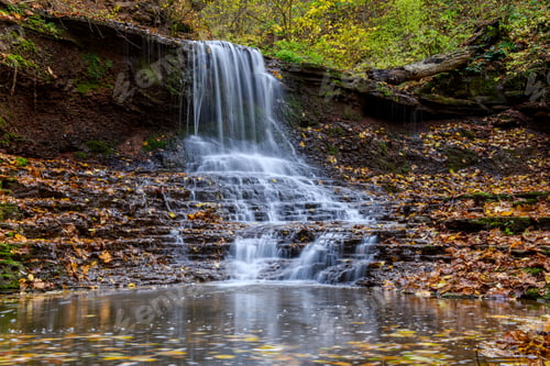 Preview: Colorful majestic waterfall in national park forest during autumn
