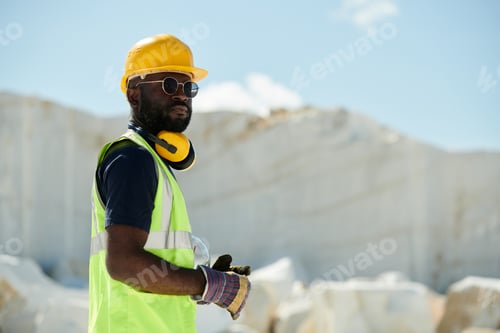 Preview: Young confident African American male engineer in workwear looking at you