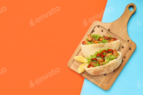 Preview: Board with pitas with chicken meat on two tone background