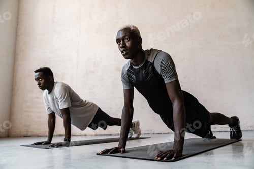 Preview: Two young african american men doing workout on exercise mat indoors