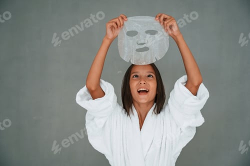 Preview: Holding mask for the face. Conception of beauty and self care. Young girl is in the studio