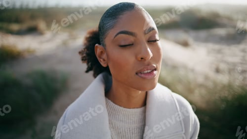Preview: Peaceful model open eyes meditating outdoors closeup. Beautiful african american
