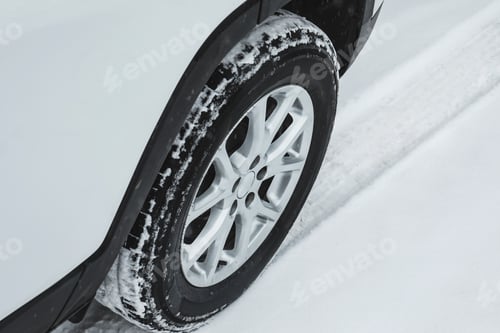 Preview: Modern car leaving tire track on snowy road, closeup view