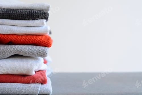 Preview: Stack of colorful folded shirts on gray table