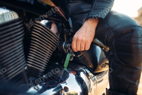Preview: Biker inserts the key in the ignition of chopper