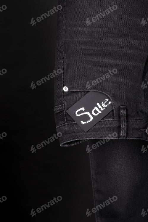 Preview: sale.Friday. Close up of black jeans with sign on background.