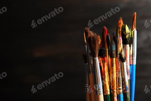 Preview: Different paint brushes on dark background, closeup. Space for text