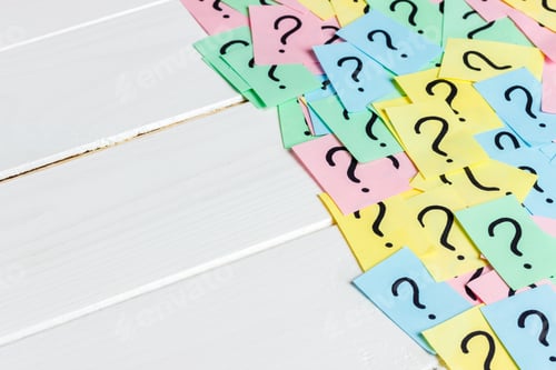 Preview: Just a lot of question marks on colored papers on wood background