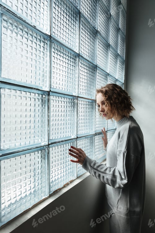 Preview: Young woman standing near window