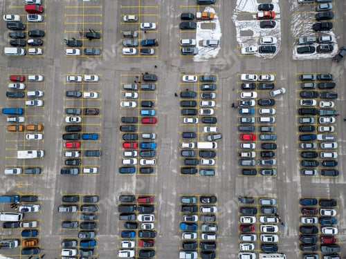 Preview: Busy parking lot filled with various vehicles during a cloudy day in an urban area
