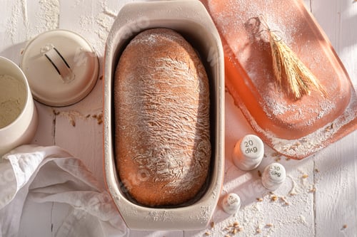 Preview: Hot loaf of bread in a ceramic baking tin.