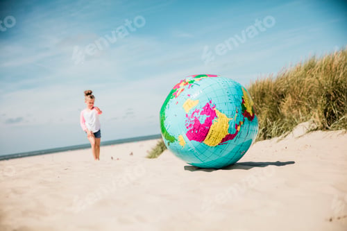 Preview: Globe on the beach with girl in background