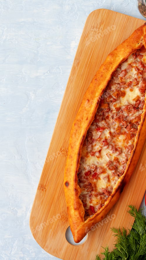 Preview: Cheese and meat filled bread on wooden board in a kitchen setting during daytime